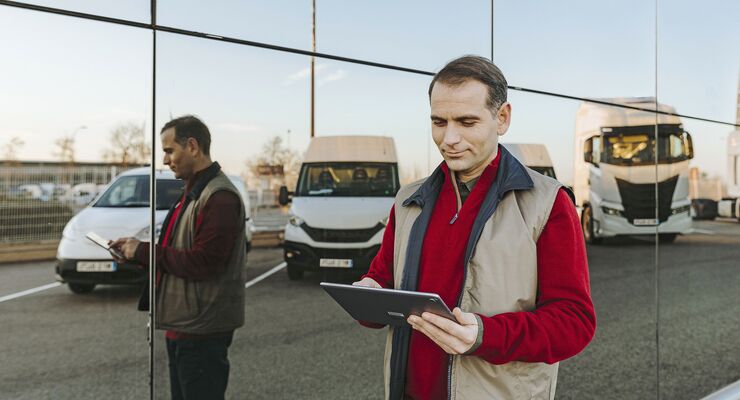 Fleet Manager mit Tablet vor Fahrzeugen